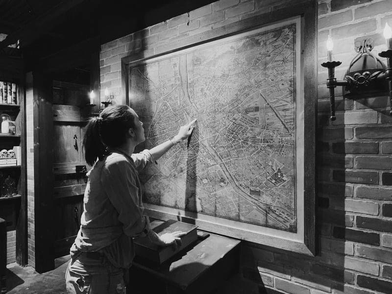 Participant studying an old map on the wall during an escape room