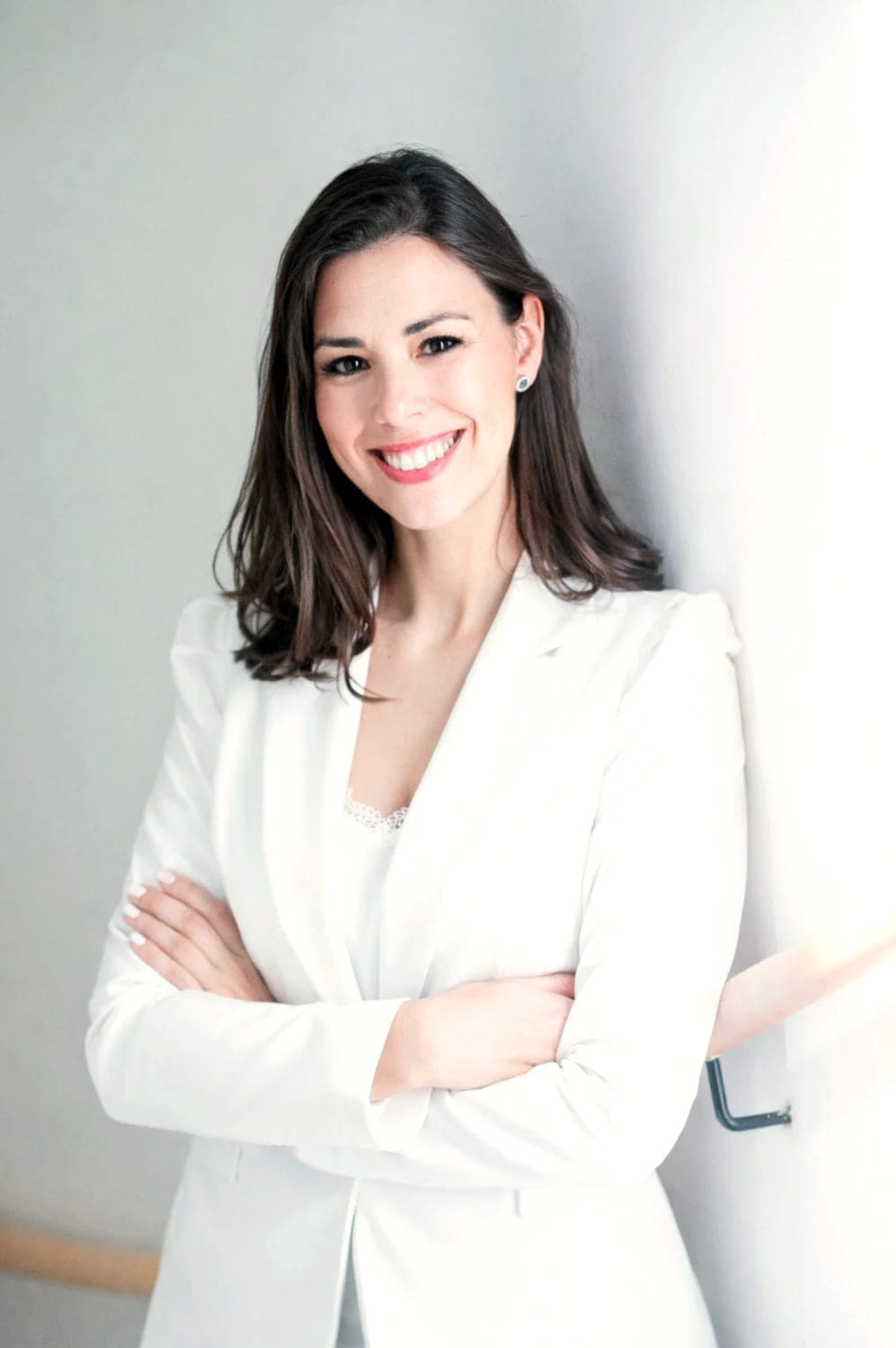Diana Plané, fundadora de Vanila Events, sonriente con americana blanca y los brazos cruzados