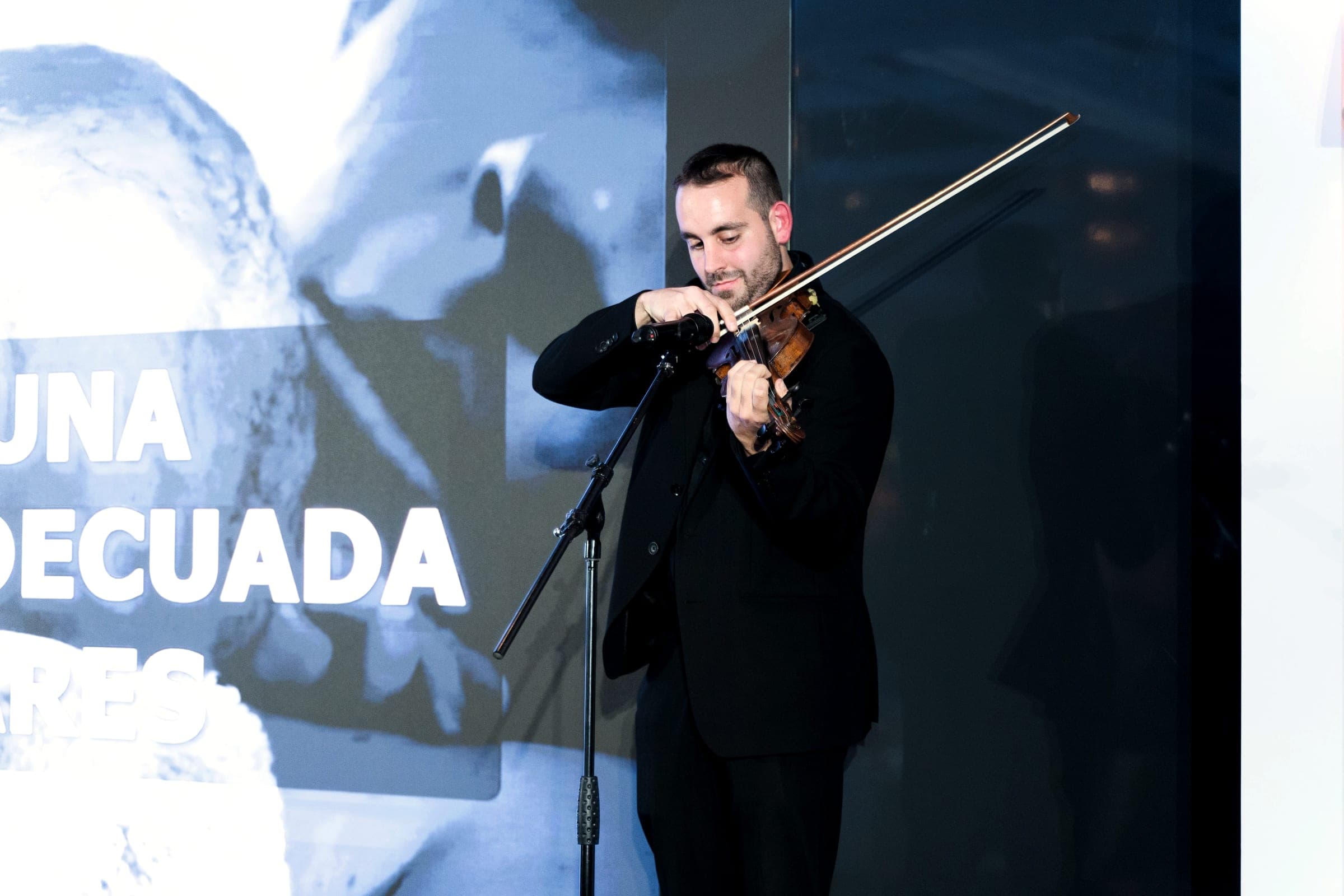 Violinist performing in front of the foundation's video projection
