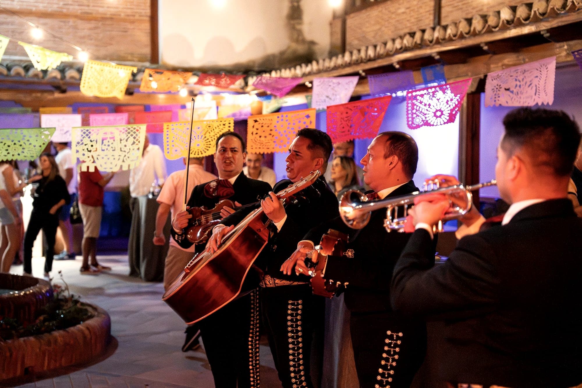 Mariachis tocando en el patio decorado con papel picado